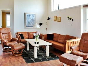 sala de estar con muebles de cuero y mesa en 8 person holiday home in R m, en Bolilmark