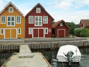 a boat docked at a dock in front of houses at Four-Bedroom Holiday home in Urangsvåg in Ervik