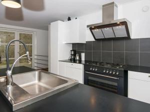 uma cozinha com um lavatório e um fogão em Four-Bedroom Holiday home in Ebeltoft 22 em Ebeltoft