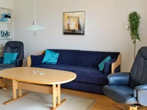 a living room with a blue couch and a table at 6 person holiday home in H jer in Emmerlev