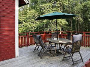 einen Tisch und Stühle mit einem Sonnenschirm auf einer Terrasse in der Unterkunft Three-Bedroom Holiday home in Hallabro in Hallabro