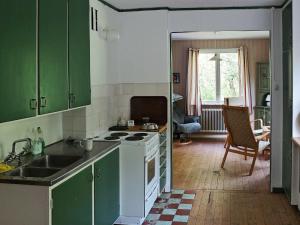 a kitchen with green cabinets and a stove top oven at Three-Bedroom Holiday home in Hallabro in Hallabro