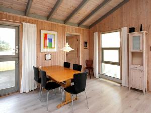 Fjand Gårdeにある5 person holiday home in Ulfborgのダイニングルーム(木製テーブル、椅子付)