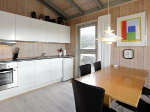 Fjand Gårdeにある5 person holiday home in Ulfborgのキッチン(木製テーブル付)、ダイニングルーム