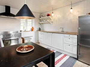 Øhuseにある6 person holiday home in Ulfborgの白いキャビネットと黒いテーブル付きのキッチン