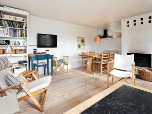 Øhuseにある6 person holiday home in Ulfborgのリビングルーム(テーブル、椅子、暖炉付)