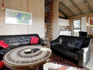Fjand Gårdeにある5 person holiday home in Ulfborgのリビングルーム(革張りのソファ、コーヒーテーブル付)