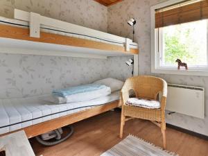 1 dormitorio con literas, silla y ventana en 4 person holiday home in Gr nna, en Gränna