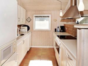 una cucina con armadietti bianchi e una finestra di 6 person holiday home in Hemmet a Hemmet