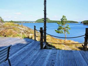 6 person holiday home in HEN N في Sundsandvik: سطح خشبي مطل على جسم ماء