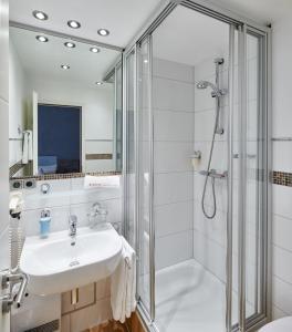 a bathroom with a shower, sink, and tub at Ambient Hotel Zum Schwan in Gelsenkirchen
