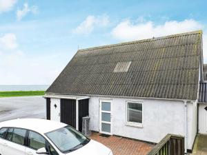 a white house with a car parked in front of it at Three-Bedroom Holiday home in Vestervig 14 in Vestervig