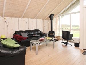 een woonkamer met een leren bank en een open haard bij 6 person holiday home in Vestervig in Vestervig