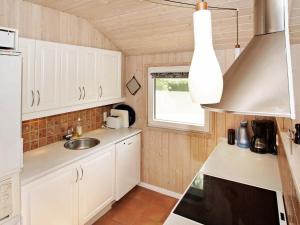 uma cozinha com armários brancos e um lavatório em 6 person holiday home in Hemmet em Hemmet