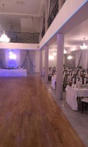 un salón de banquetes con mesas blancas y manteles blancos en Villa Szamocin, en Varsovia
