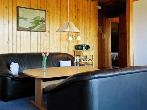 a living room with a table and a leather couch at 8 person holiday home in Harbo re in Vrist