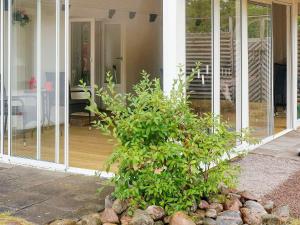 a house with a bush in the front yard at 6 person holiday home in Laholm in Laholm