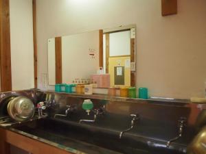 a bathroom counter with a sink and a mirror at Shukubo Kanbayashi Katsukane in Tsuruoka +34 photos