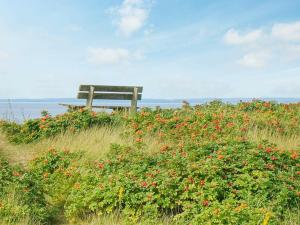 un banco sentado en la parte superior de un campo de flores en 6 person holiday home in Laholm en Laholm