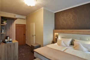 a bedroom with a bed and a dresser at Ambient Hotel Zum Schwan in Gelsenkirchen