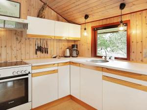 Mosevråにある6 person holiday home in Oksb lの白いキャビネット、シンク、窓付きのキッチン