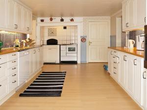 uma grande cozinha com armários brancos e piso em madeira em 6 person holiday home in STOCKARYD em Stockaryd