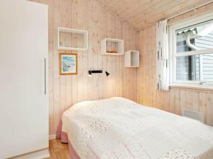 1 dormitorio con cama y ventana en Holiday home Sæby II, en Saeby