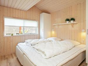 ein großes weißes Bett in einem Zimmer mit Fenster in der Unterkunft 6 person holiday home in Tranek r in Tranekær