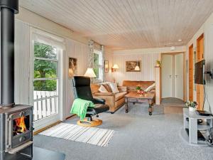 - un salon avec une chaise et une cheminée dans l'établissement 8 person holiday home in Struer, à Struer