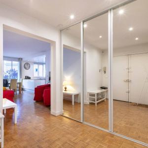 a living room with a red couch and a glass wall at Paris City - Spacious 3 rooms flat for families - 3 minutes from metro station in Paris