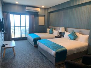 a hotel room with two beds and a window at Chi Shing Hai Hotel in Dahan