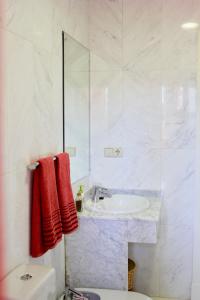 a white bathroom with a sink and a mirror at Apartamento Playa y Golf con PARKING INCLUIDO in Motril