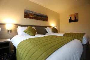 a hotel room with two beds with green sheets at Malvina House Hotel in Stanley