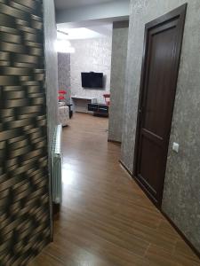 an empty hallway with a door and a living room at Your home in Kutaisi