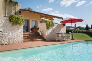 a house with a swimming pool and an umbrella at Maso Maroni Agriturismo in Quinto di Valpantena