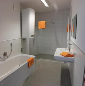 a white bathroom with a tub and a sink at Appartement Juns in Tux