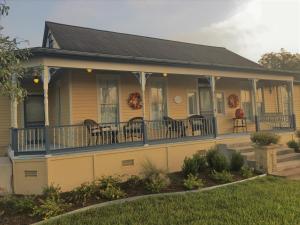 a house with a porch with chairs on it at Das Meyer Haus - Luxe Victorian in Schulenburg