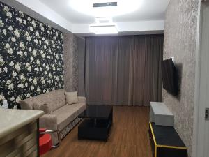 a living room with a couch and a tv at Your home in Kutaisi