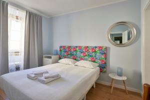 リスボンにあるElegant Riverview Apartment in Historical Lisbonのベッドルーム(カラフルなヘッドボード付きの大きな白いベッド1台付)