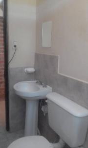 un bagno bianco con un water e un lavandino di SOL PATAGONICO a Playas Doradas Altre 17 foto