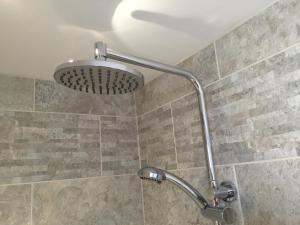 een douche met een douchekop in de badkamer bij SeaSure in Bexhill