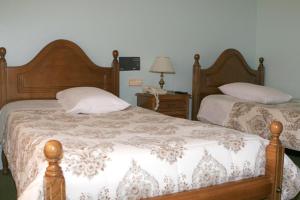 Hotel Xallas في Santa Comba: غرفة نوم بسريرين وطاولة بها مصباح