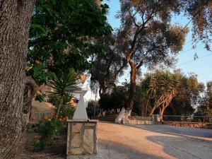 ein weißes Denkmal neben einem Baum in der Unterkunft Angelos Studios in Parga