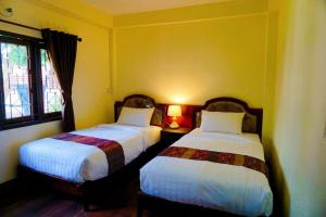 Postel nebo postele na pokoji v ubytování Punyin Hotel Inthanon -ปั้นหยิ่น โฮเทล