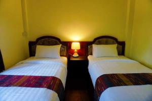 Postel nebo postele na pokoji v ubytování Punyin Hotel Inthanon -ปั้นหยิ่น โฮเทล
