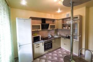 cocina con nevera blanca y fregadero en PaulMarie Apartments on Zaslonova Street 70, en Soligorsk
