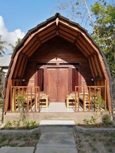 a gazebo with a large wooden door and benches at Bale Hostel in Kuta Lombok