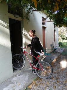 una mujer está parada con una bicicleta fuera de una puerta en nel cuore della città, en Urbania