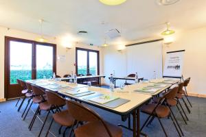 a meeting room with a long table and chairs at Campanile Nevers Nord - Varennes-Vauzelles in Varennes Vauzelles