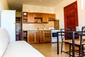 eine Küche mit Holzschränken und einem Tisch im Zimmer in der Unterkunft Vittoria House Apartments 209-210 in Bayahibe